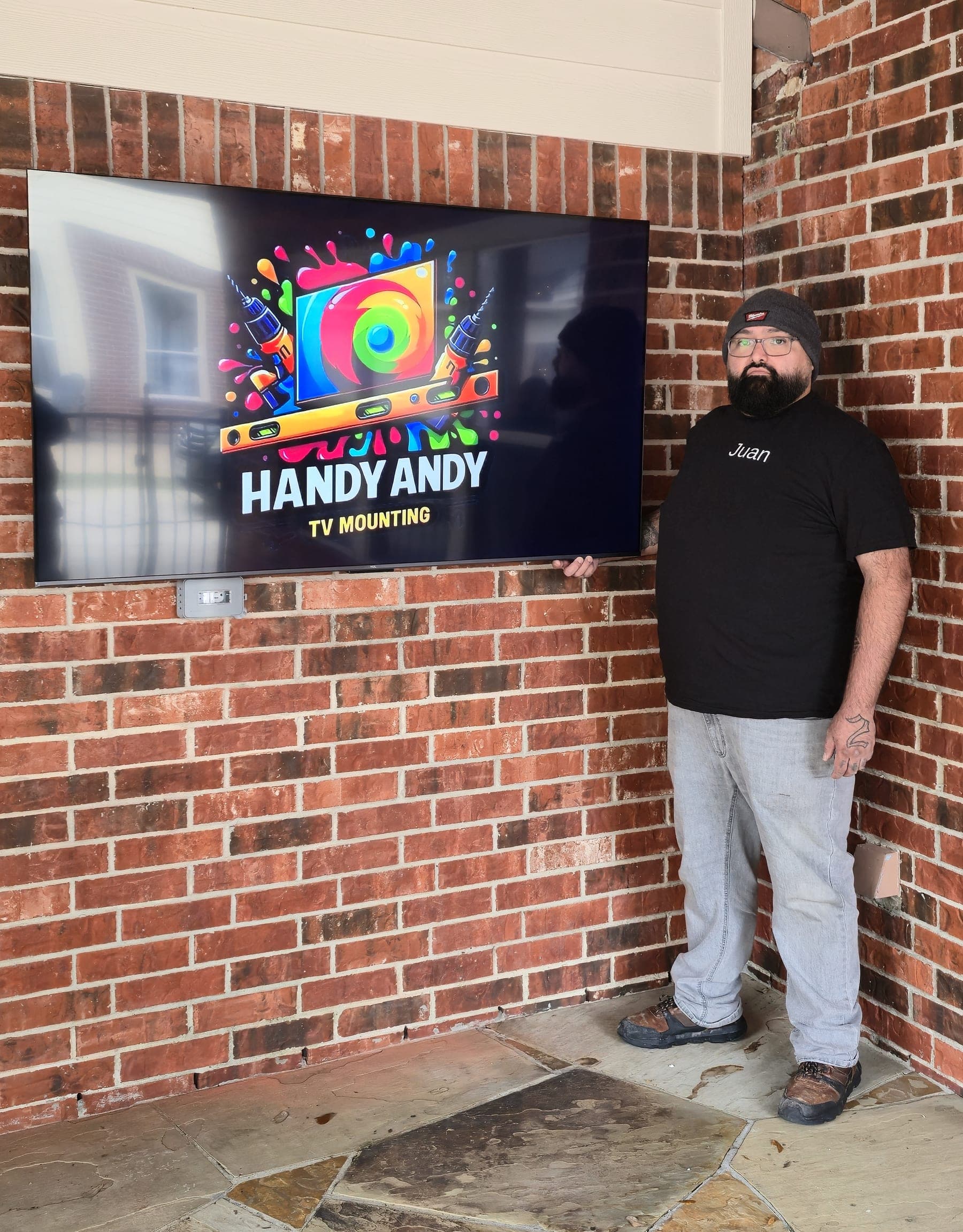 Outdoor TV mounted on a brick patio wall