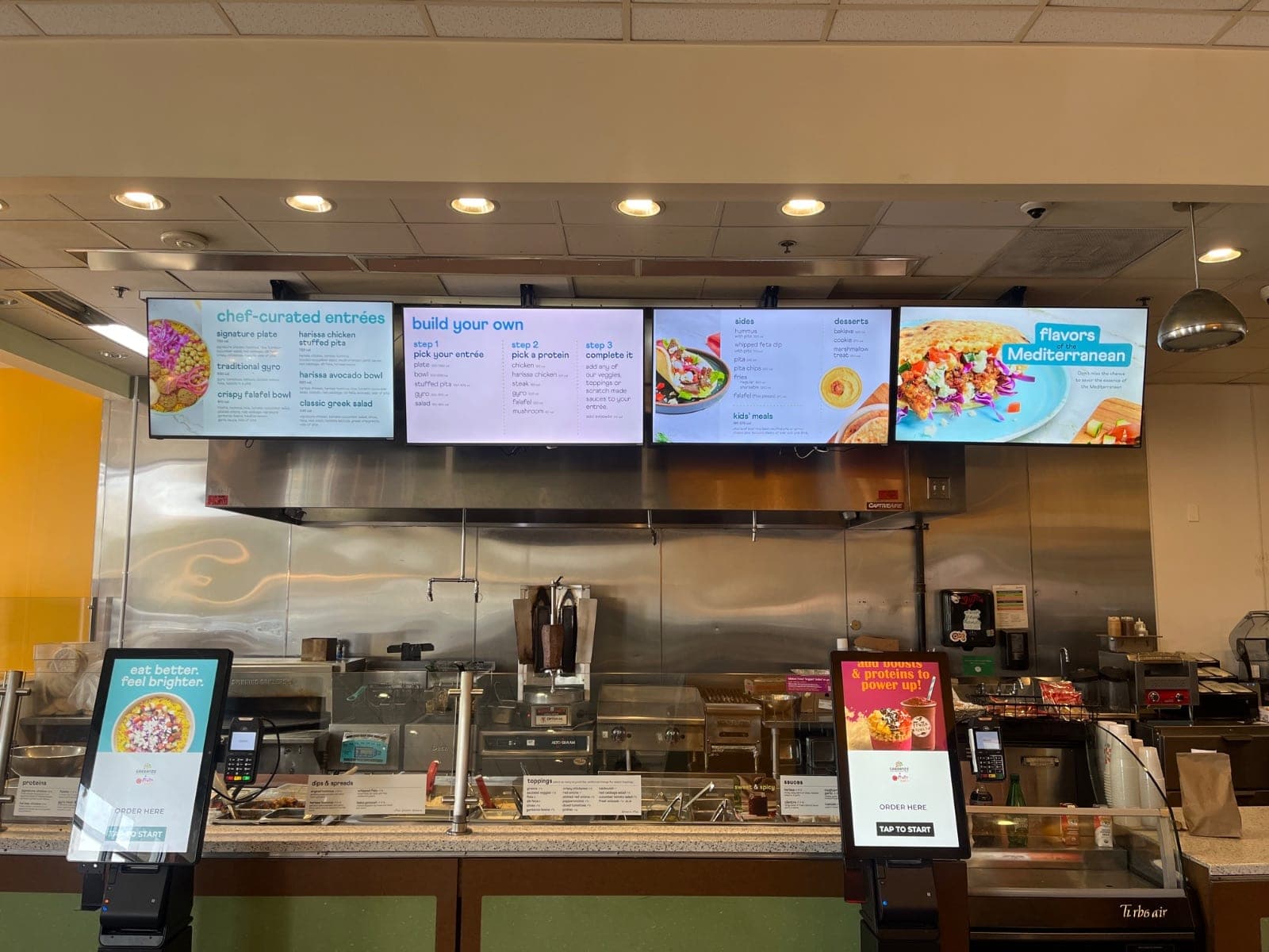 Four menu board displays mounted in a row at an Austin restaurant