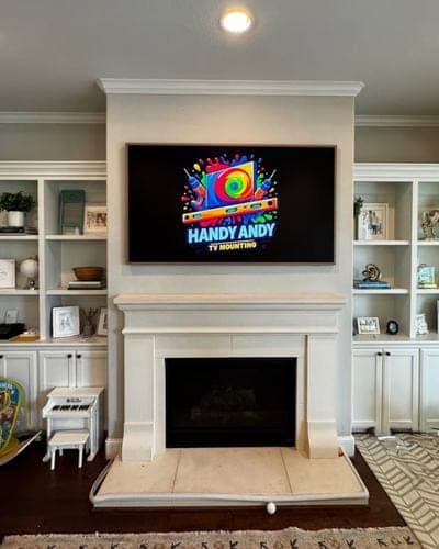 TV mounted over a cast stone fireplace between built-in shelves