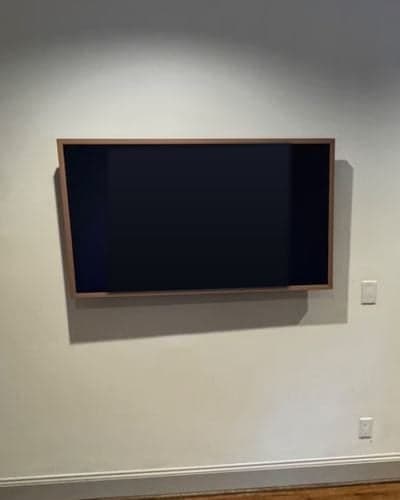 Samsung Frame TV with wood bezel mounted flush on a wall in Austin