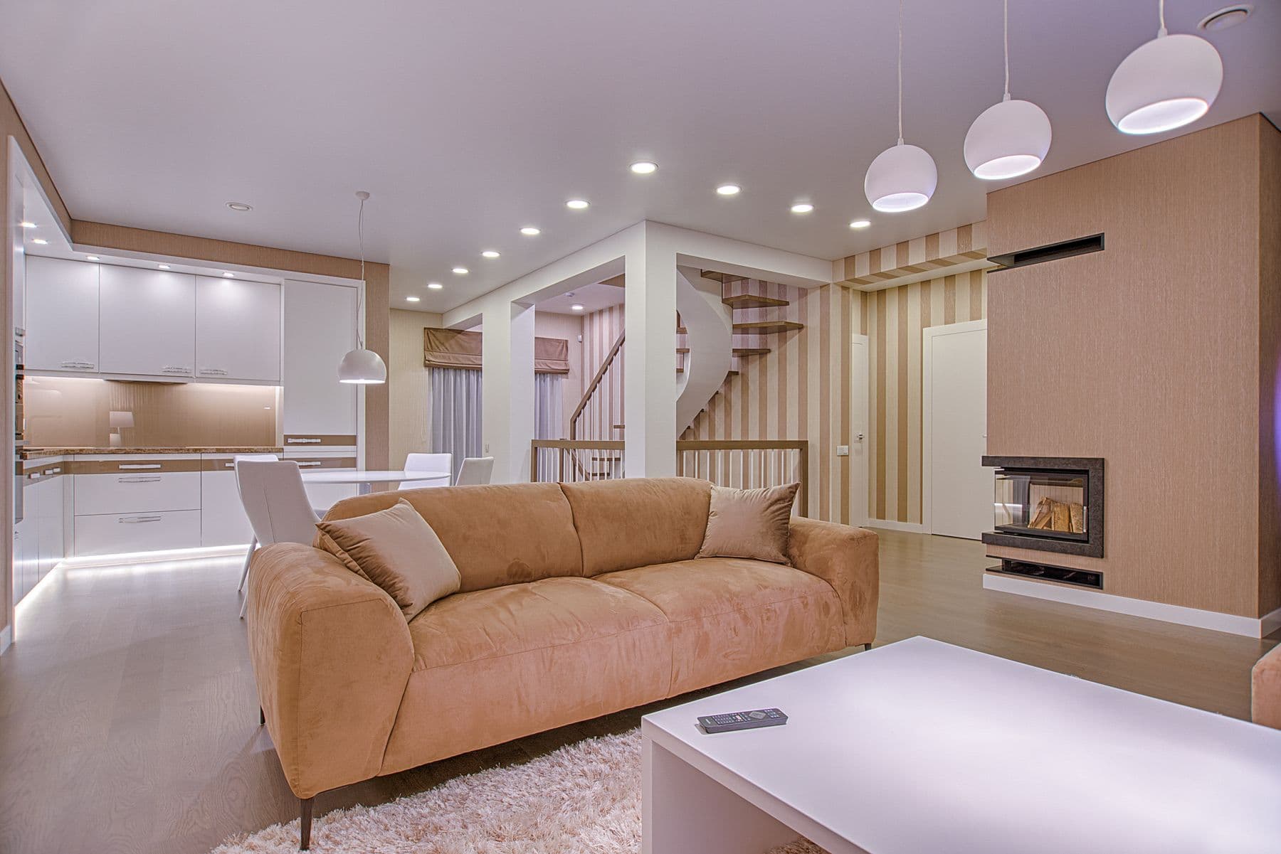Well-furnished open-plan living room with a large sofa, dining area and fireplace