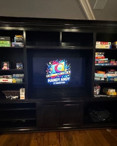 TV mounted inside a dark built-in media wall