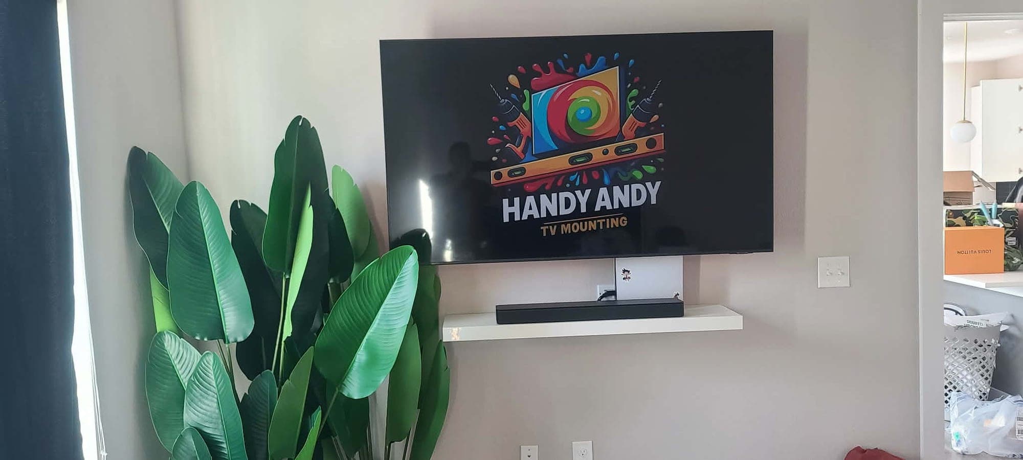 Mounted TV with soundbar and floating shelf in an Austin home